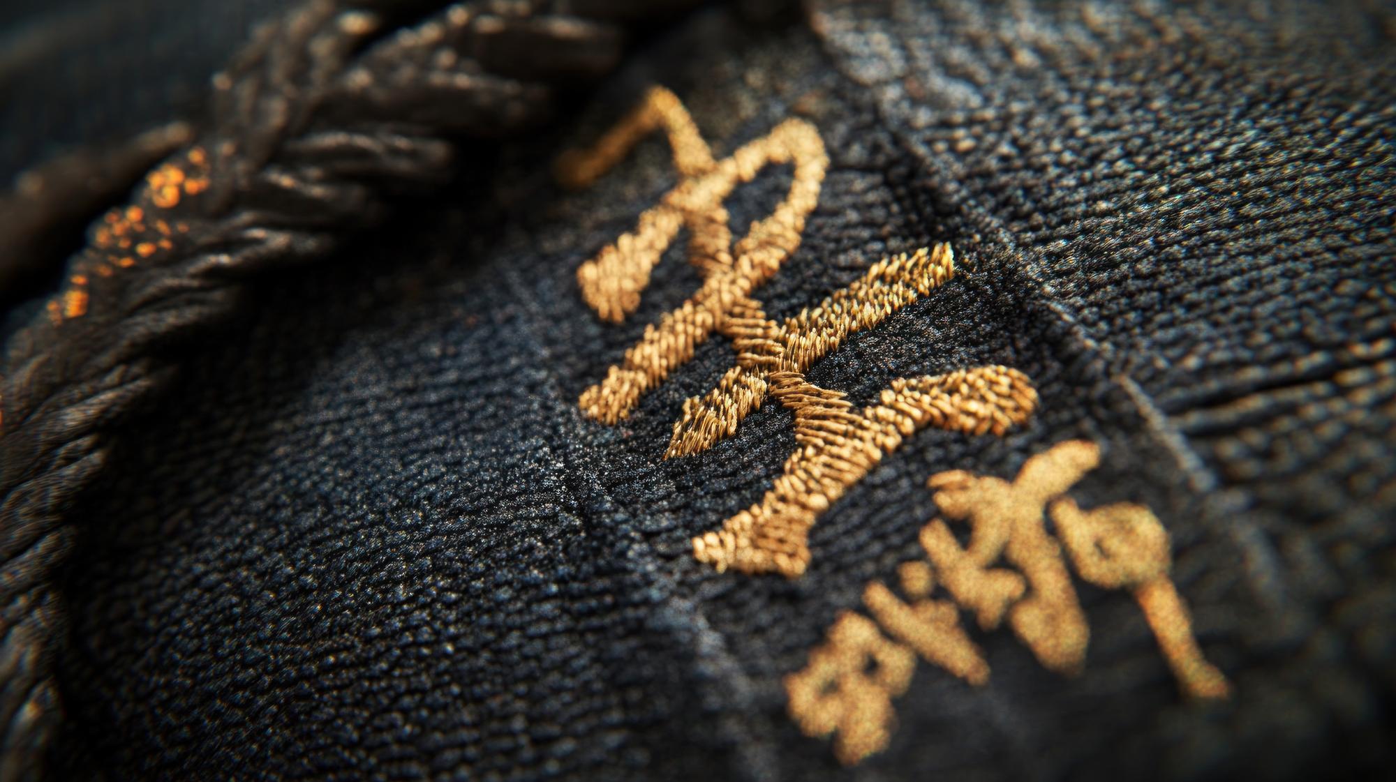 detailed gold thread embroidery on dark fabric